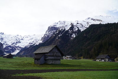 Scenic view of field and houses against sky