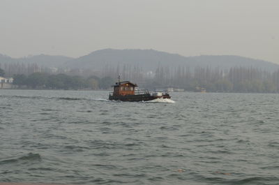 Boat sailing on sea against sky