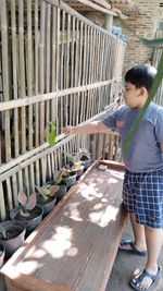 Full length of boy standing on wooden wall