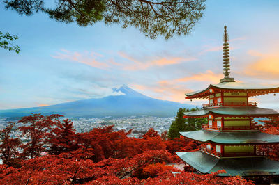 View of temple by building against sky