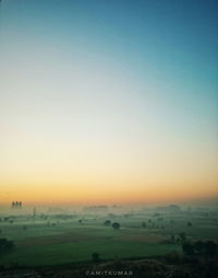 Scenic view of field against clear sky during sunset