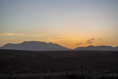 Scenic view of desert against sky during sunset