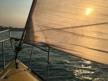 Sailboat sailing on sea at sunset