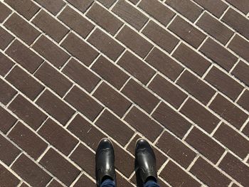 Low section of man standing on tiled floor