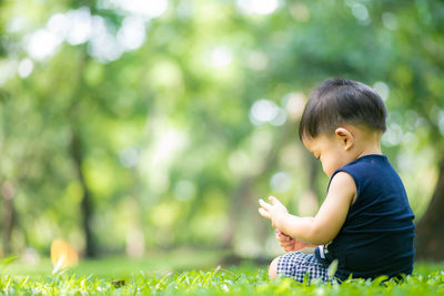 Cute boy sitting on land