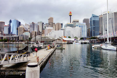 City at waterfront against cloudy sky