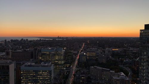 Aerial view of modern buildings against sky during sunset