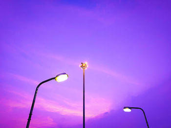 Low angle view of illuminated street light against blue sky