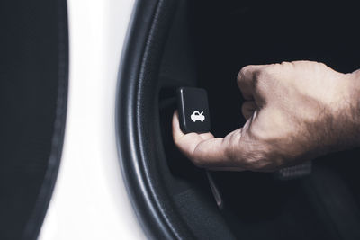 Close-up of man hand pulling button in car