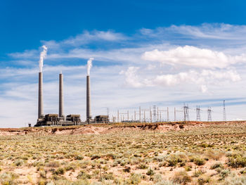 Factory on field against sky