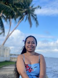 Portrait of young woman swimming in sea against sky