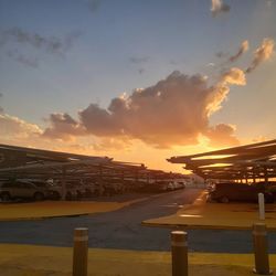 Airplane on airport runway against sky during sunset