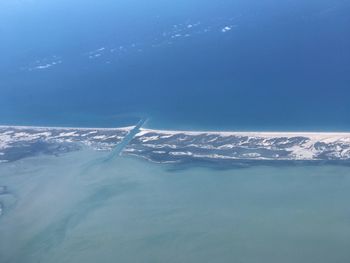 Aerial view of sea against blue sky