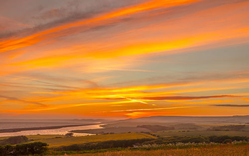 Scenic view of field against orange sky