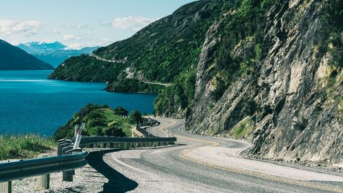 Scenic view of road by sea against sky