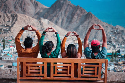 Rear view of people sitting on mountain