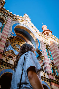 Low angle view of woman standing by church in city