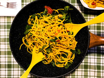 High angle view of homemade pasta with inkfish, rocket salad and turmeric 