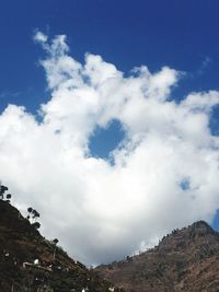 Low angle view of mountain against cloudy sky