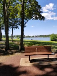 Bench on landscape against sky