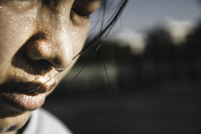 Close-up of young woman sweating in sunny day