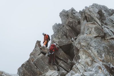 Two climbers descending exposed ridge on icy day