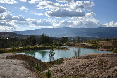 Scenic view of river by mountains against sky