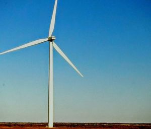 Low angle view of wind turbine against blue sky