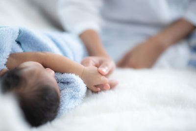 Close-up of baby lying on bed