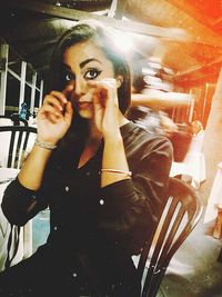 Portrait of woman sitting on chair in restaurant