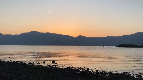 Scenic view of lake against sky during sunset