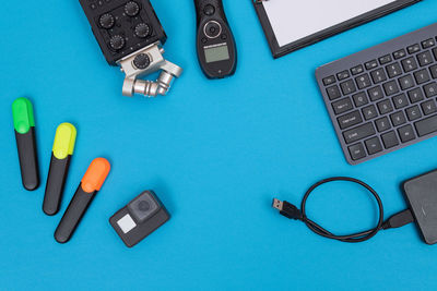 Directly above shot of usb and equipment on turquoise background