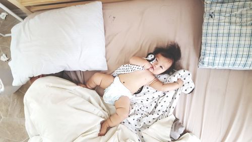 High angle view of girl lying down on bed