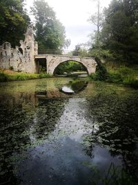 Arch bridge over lake against sky