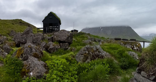 Built structure on land by mountain against sky