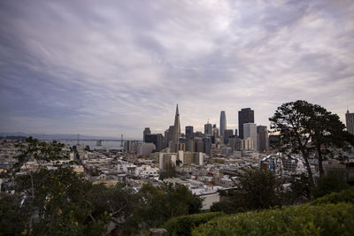 View of cityscape against cloudy sky