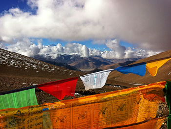 Low angle view of prayer flags against cloudy sky