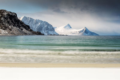 Scenic view of sea and mountains against sky