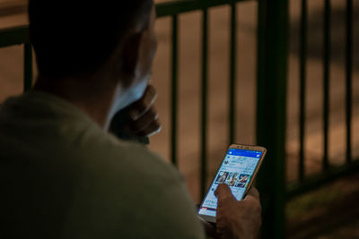 Midsection of man using mobile phone