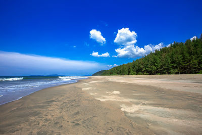 Scenic view of beach against blue sky