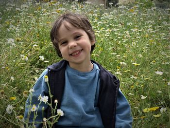 Portrait of smiling teenage boy standing amidst plants