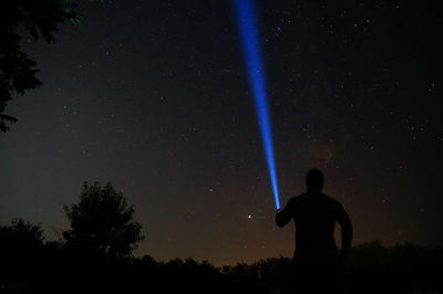 Silhouette man standing against sky at night