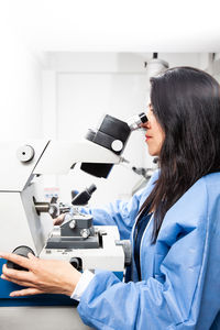 Young female scientist using an ultramicrotome to make sections for the electron microscope.