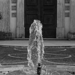 Close-up of fountain in city against building