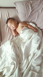 High angle view of baby boy sleeping on bed