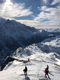 High angle view of people on snowcapped mountain against sky