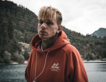 Portrait of young man standing against sea