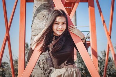 Portrait of beautiful smile women playing with red bridge and blue sky on background.