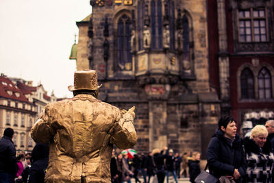 People walking on road against built structures