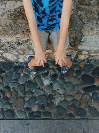 Low section of child standing on stone wall